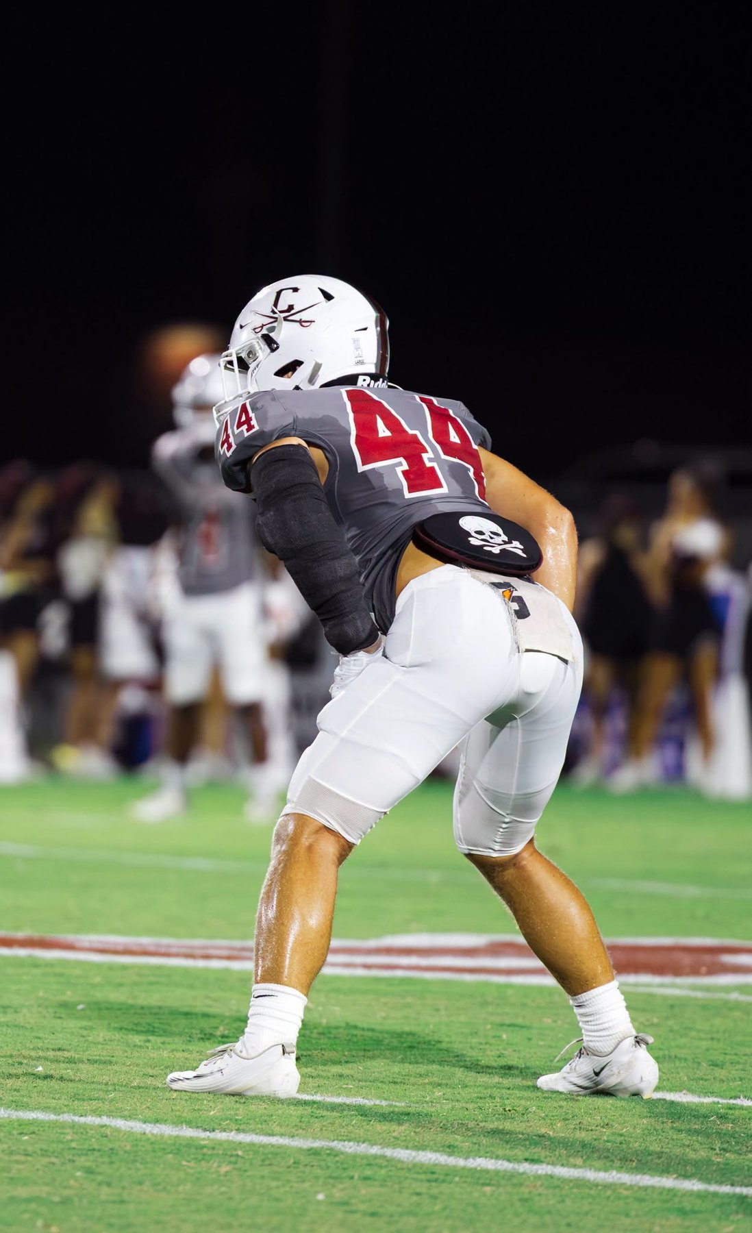 A Caledonia player crouches, ready to move, seen from behind