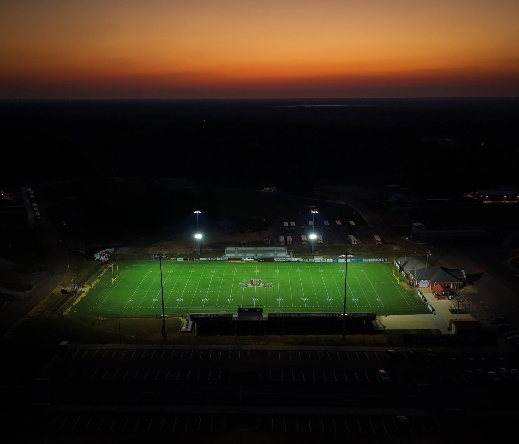 Caledonia's stadium lit up at dusk, seen from above