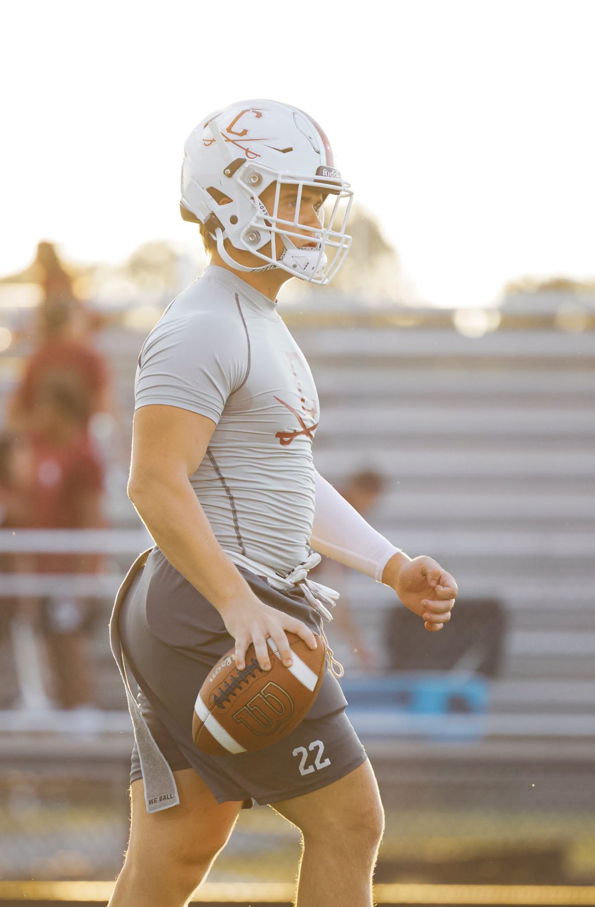 A Caledonia player holds the ball in the evening light before the game