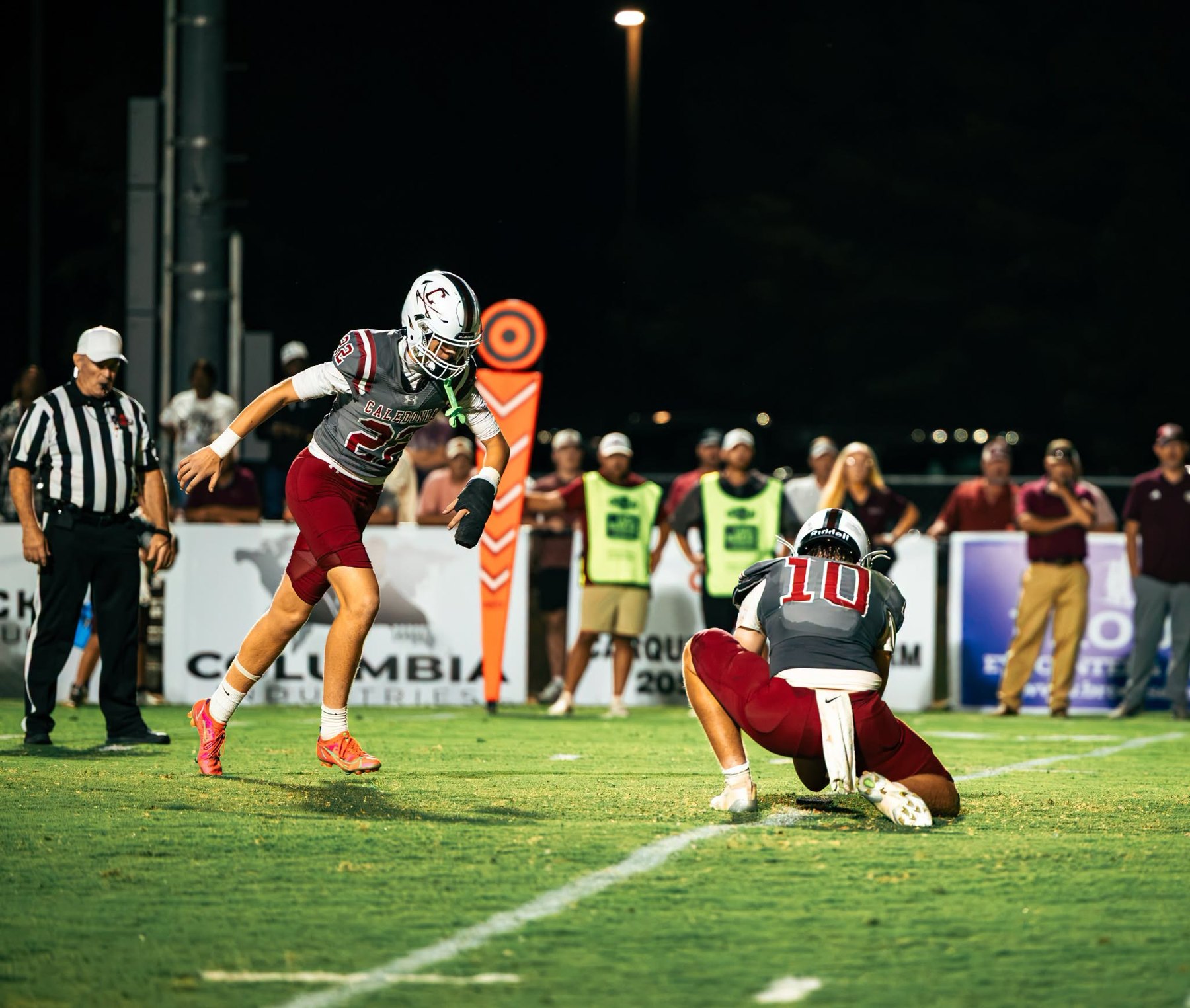 Caledonia sets up a kick, the holder down and the kicker stepping in