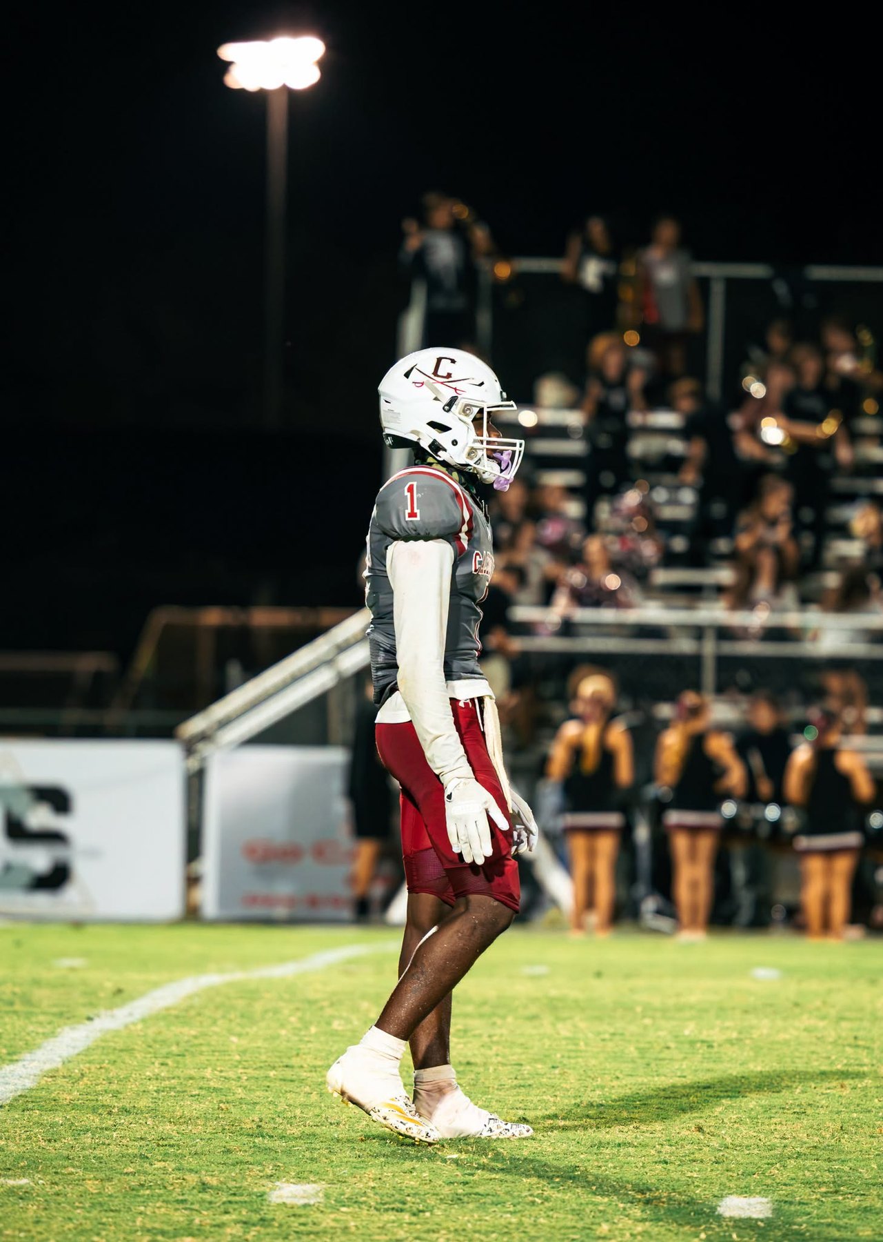 A Caledonia player walks the field under the lights against East Webster