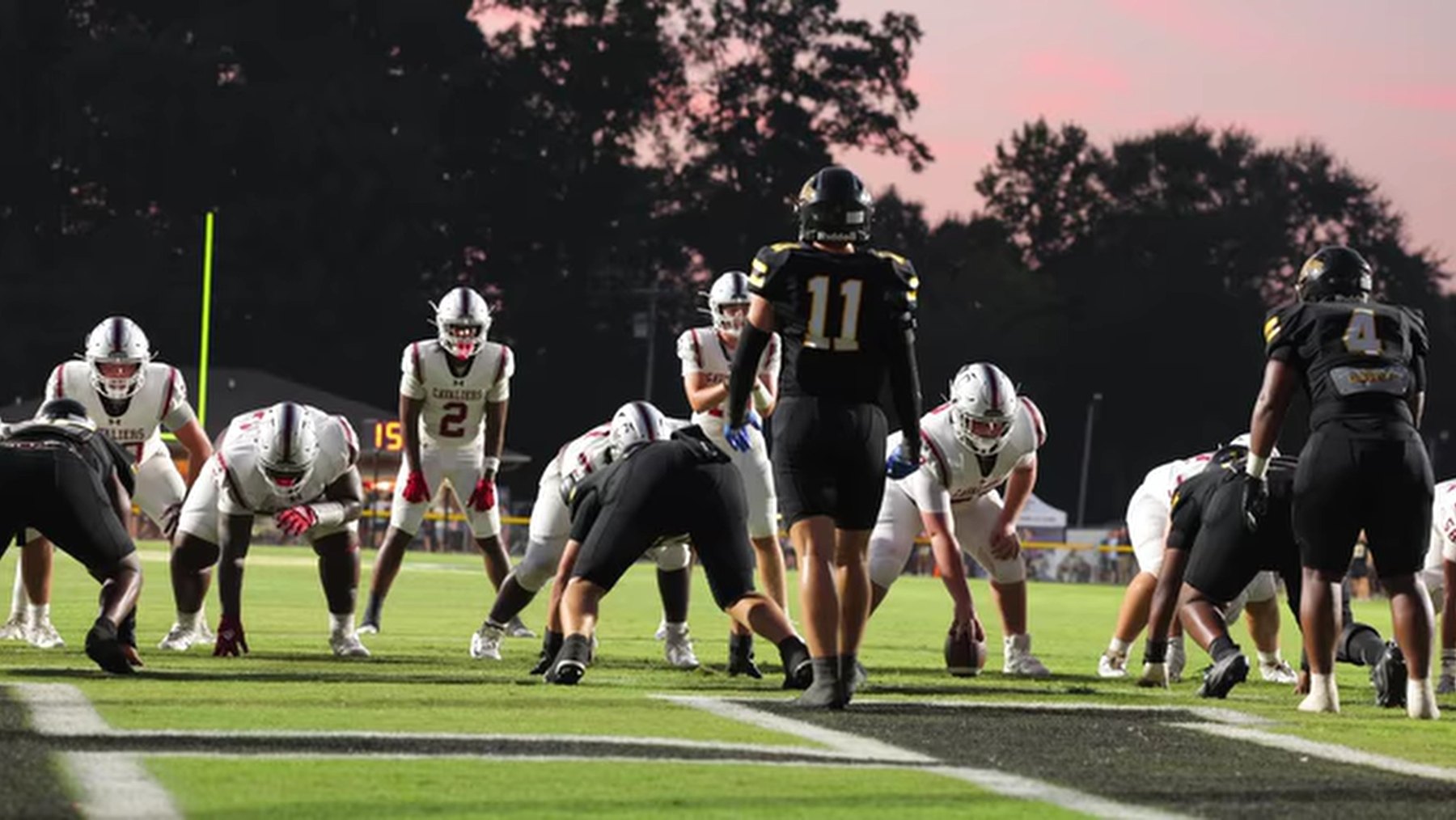 Caledonia's offense sets up over the ball against Itawamba AHS at dusk